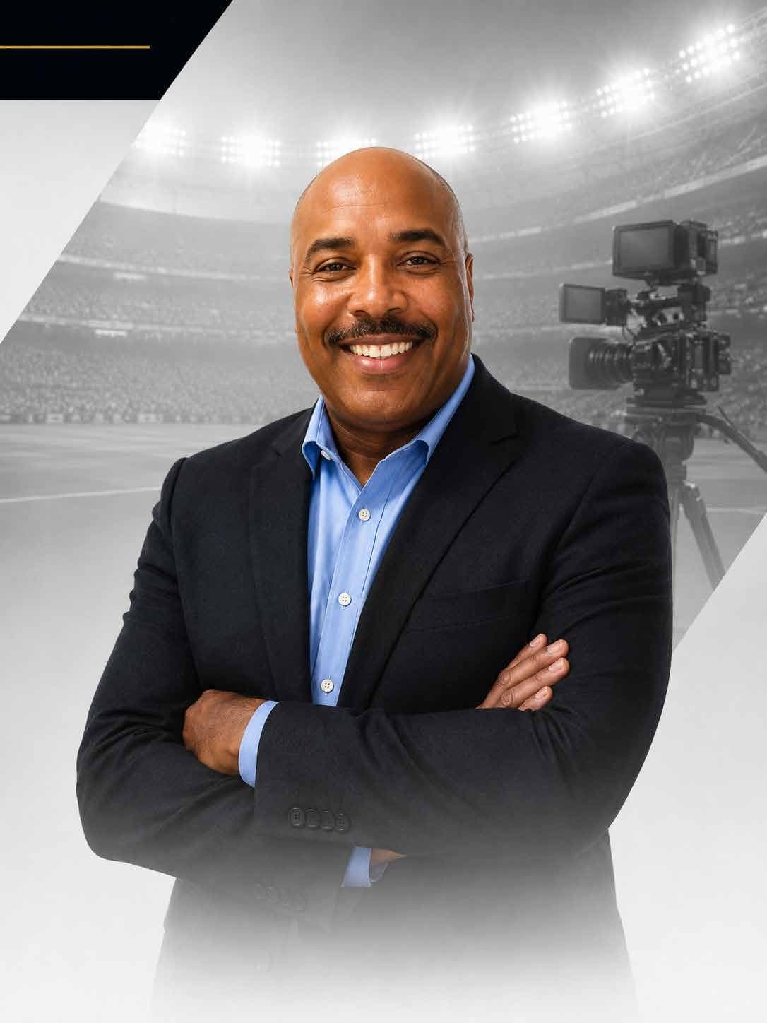 Anthony “AD” Daughtry in a suit, arms folded, before a stadium backdrop.
