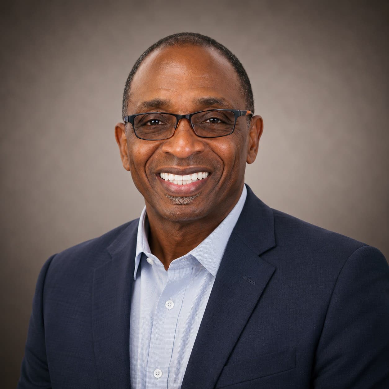 Huel Cox in a navy suit, studio portrait.